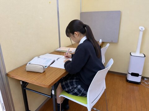 仕切りのある自習コーナーで勉強する生徒